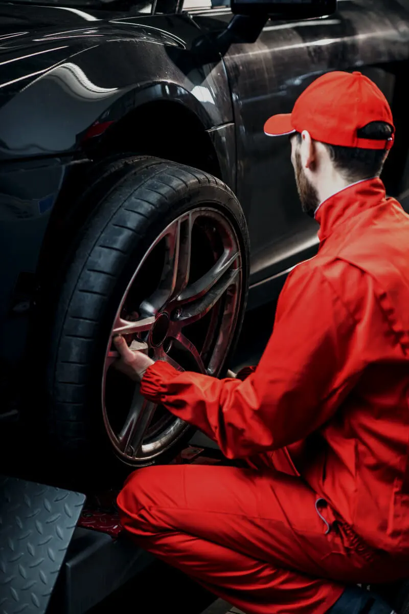 Automotive technician performing a wheel and tire inspection during professional vehicle maintenance
