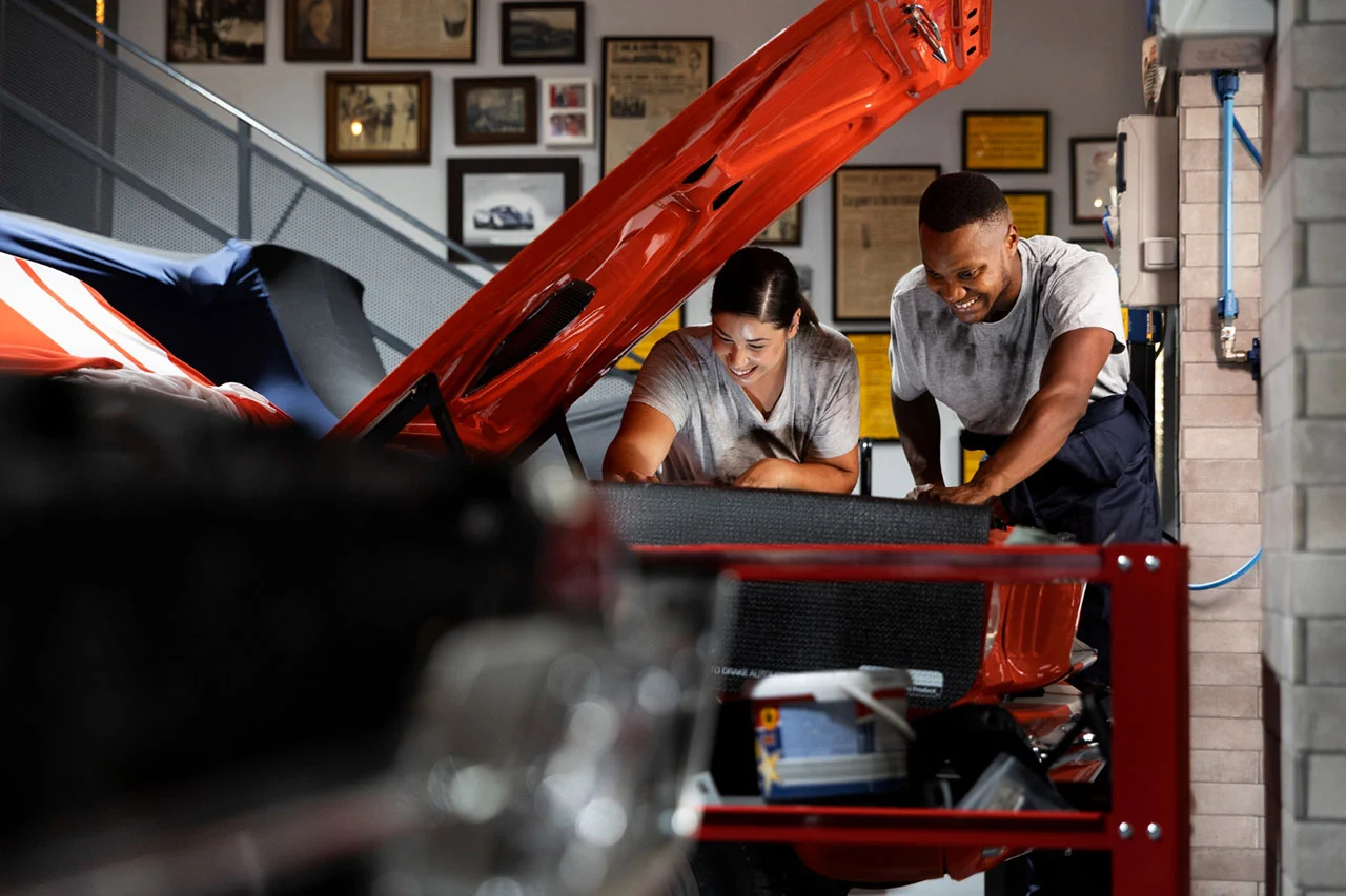 Auto mechanics inspecting and repairing a car engine during professional vehicle maintenance in a workshop