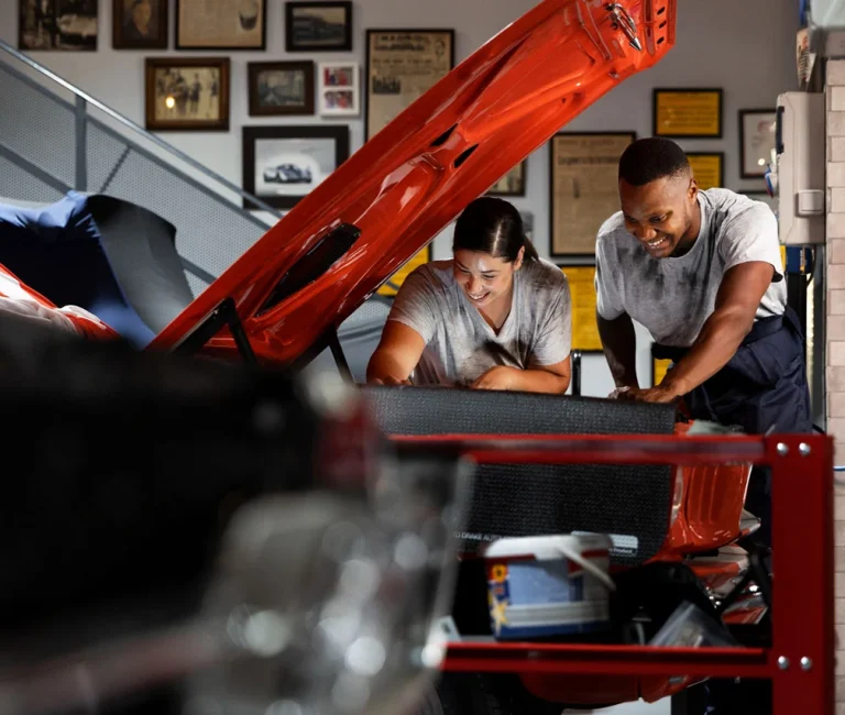 Auto mechanics inspecting and repairing a car engine during professional vehicle maintenance in a workshop